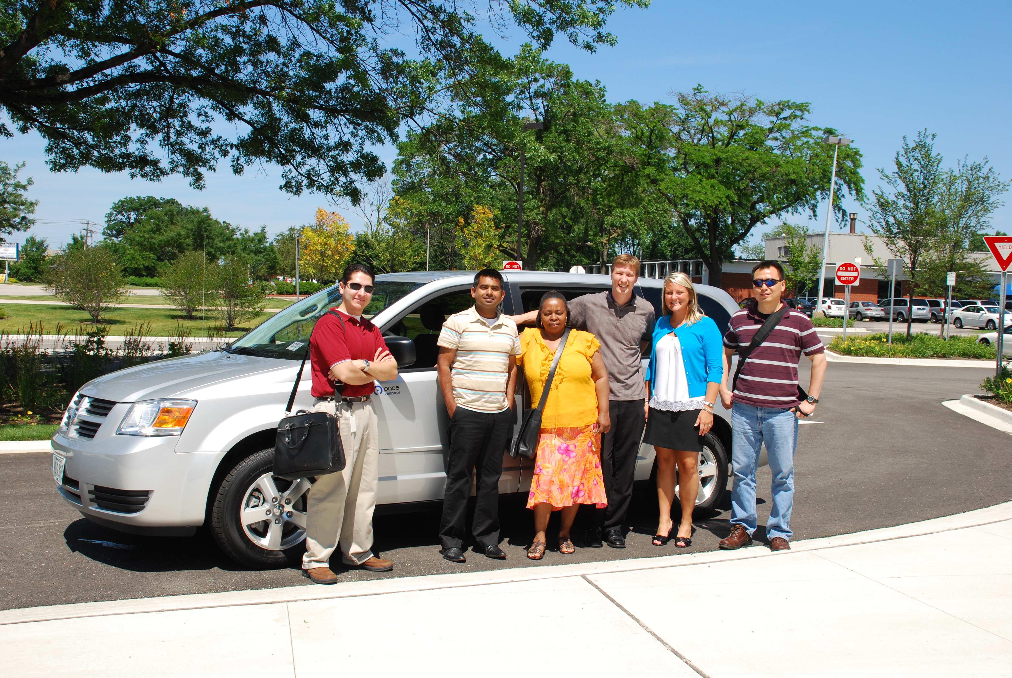 Commuters standing together by a Pace van