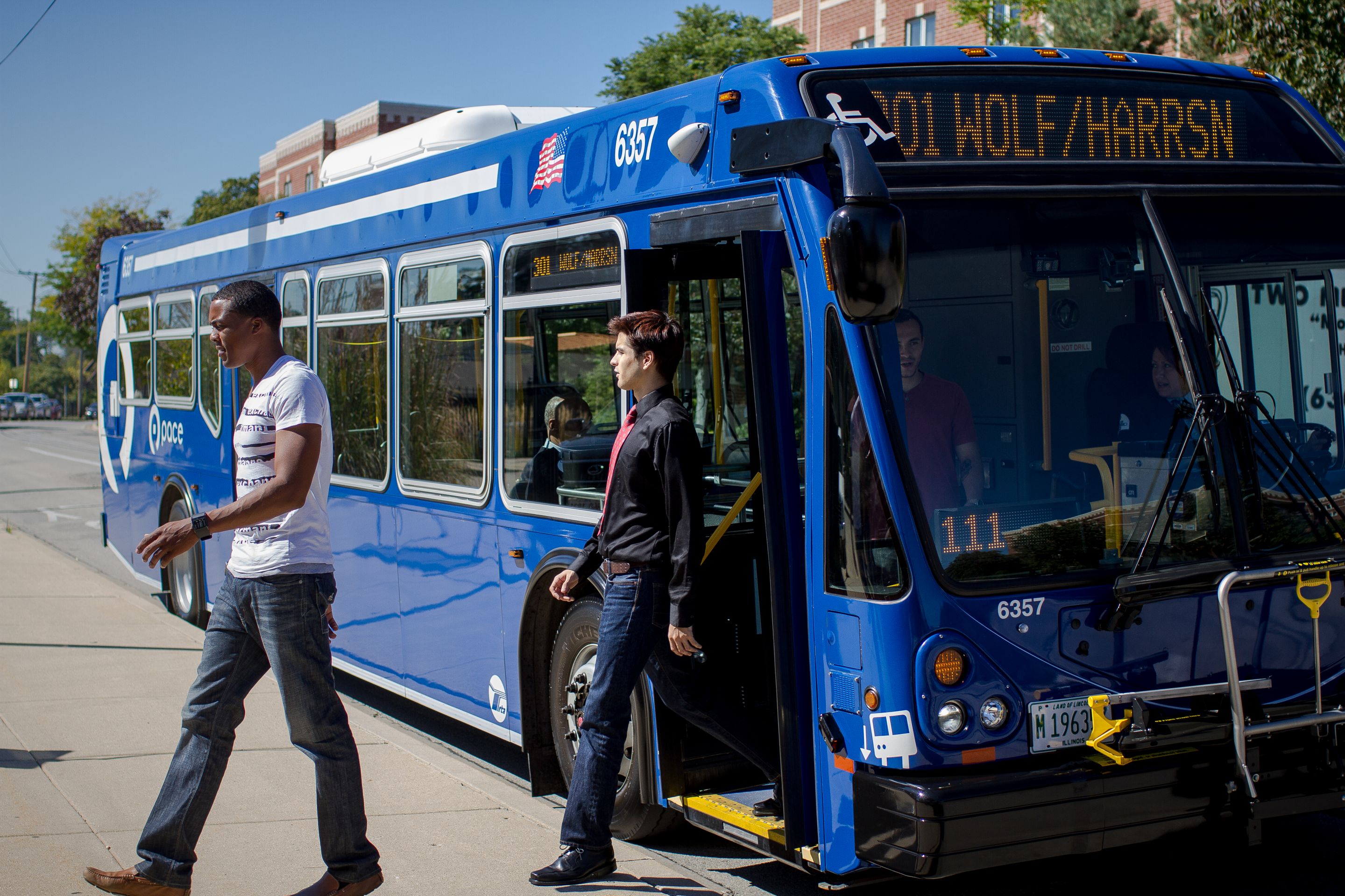 Two passengers deboard a Pace bus on Route 301